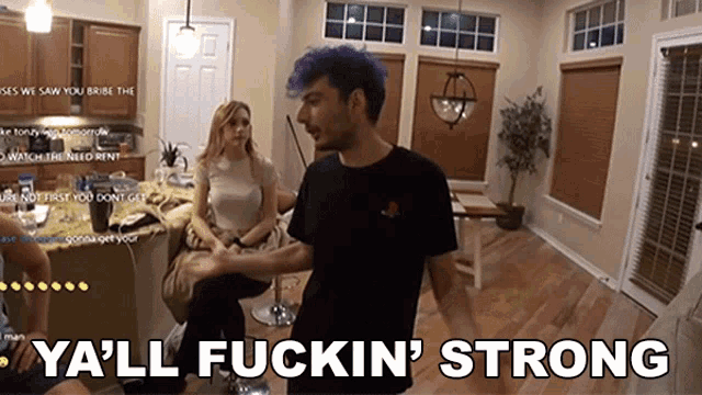 a man with purple hair says ya 'll fuckin ' strong in a living room