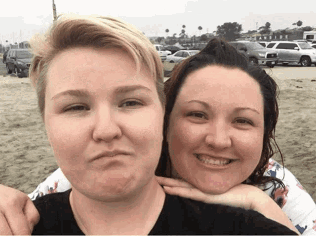 two women posing for a picture with one making a face