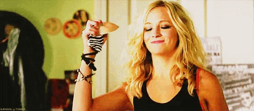 a woman in a black tank top is holding a pair of socks in her hand .