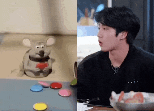 a man is sitting at a table next to a toy mouse .