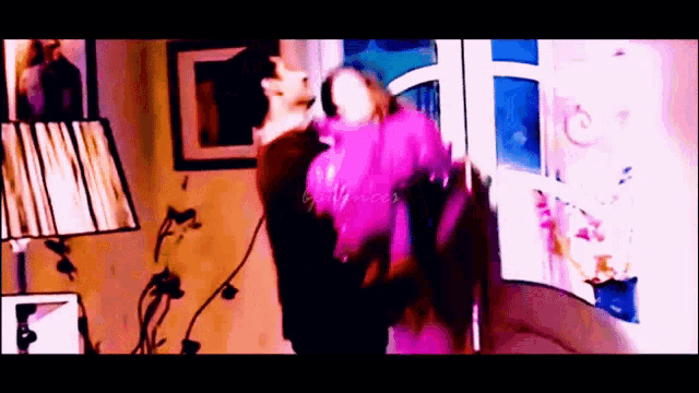 a woman in a pink jacket is dancing in a room