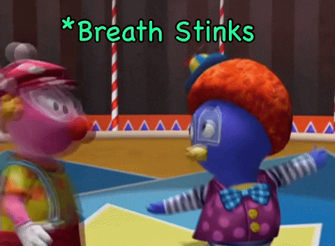 a clown and a penguin are standing next to each other with the words " breath stinks " above them