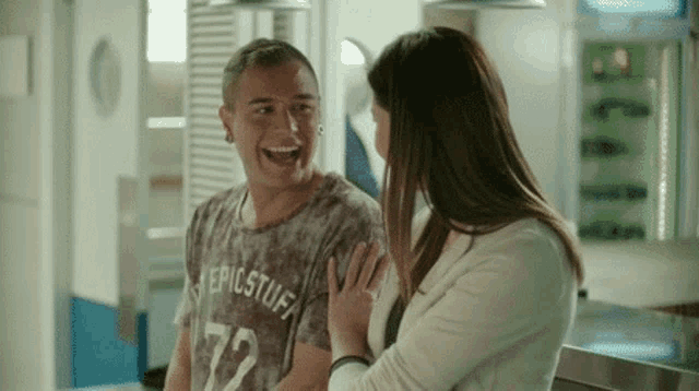 a woman is putting her hand on a man 's chest while he is laughing .