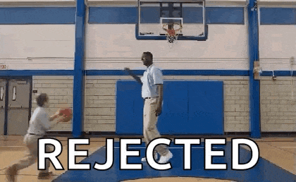 a man is playing basketball in a gym with the words `` rejected '' written on the floor .