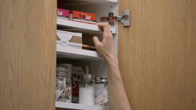 a woman is reaching into a shelf with a box of ps4 on it .