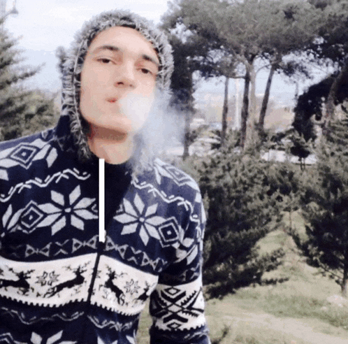 a man wearing a sweater with snowflakes on it is smoking