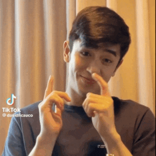 a young man is making a funny face with his fingers .
