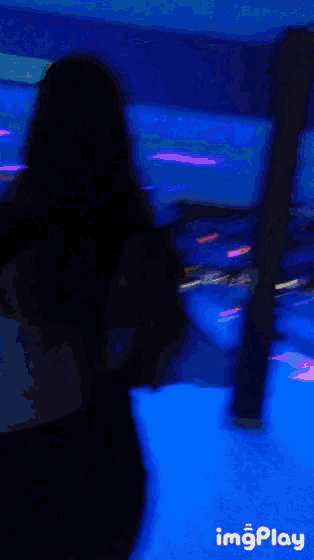 a woman is walking down a bowling alley with the words imgplay in the bottom right corner