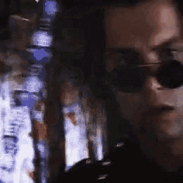 a close up of a man wearing sunglasses and a black shirt