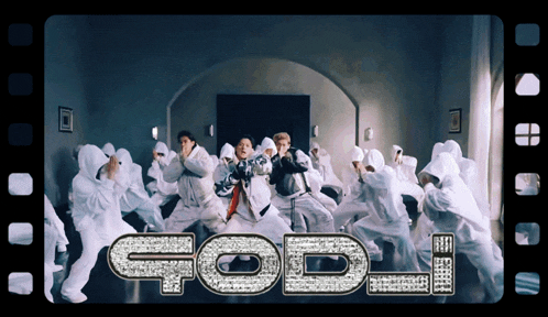 a group of people are dancing in a room and the word god is visible