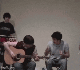 a man playing an acoustic guitar in front of a group of people with imgflip.com at the bottom