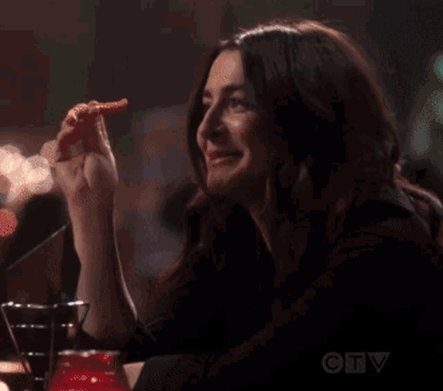 a woman sitting at a table with a christmas tree in the background and a ctv logo