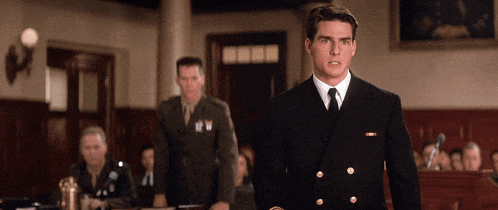 a man in a navy uniform stands in front of a group of men