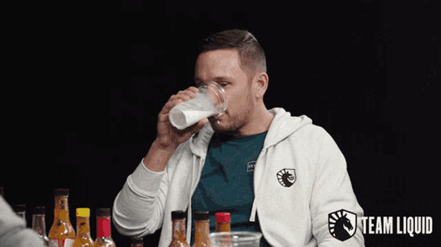 a man drinking from a cup with the word team liquid on it