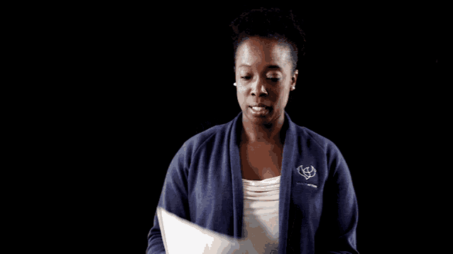 a woman holding a piece of paper with a toyota logo on her sweater