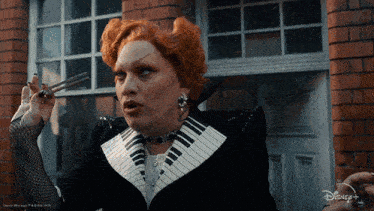 a woman with red hair is wearing a black and white suit with a piano keyboard collar