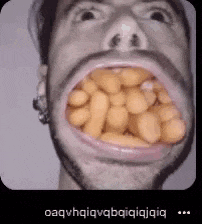 a close up of a man 's mouth filled with beans