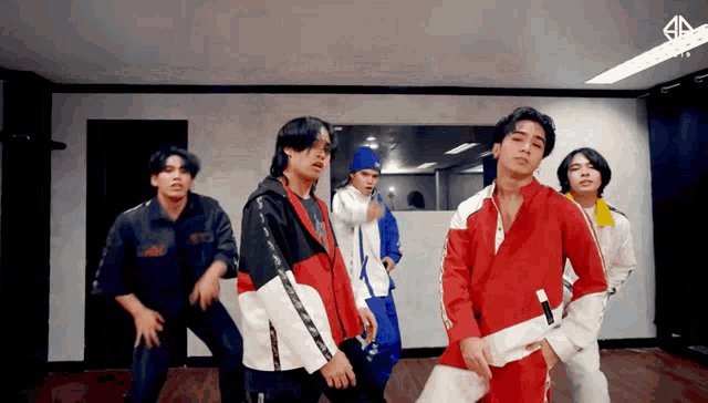 a group of young men are dancing in front of a mirror with the letter a on the bottom