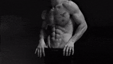 a black and white photo of a shirtless man with calvin klein underwear on