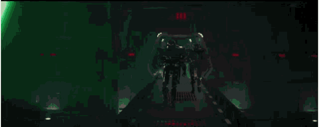 a group of people are standing next to each other in a dark room with a green light coming out of a green light saber .
