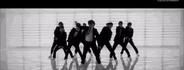 a group of people are dancing in a black and white photo .