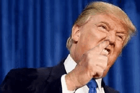 donald trump is making a funny face while giving a thumbs up .