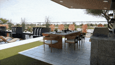 a patio with a table and chairs and a waterfall in the background