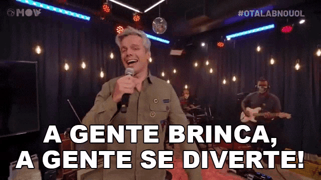 a man singing into a microphone with the words a gente brinca a gente se divertie