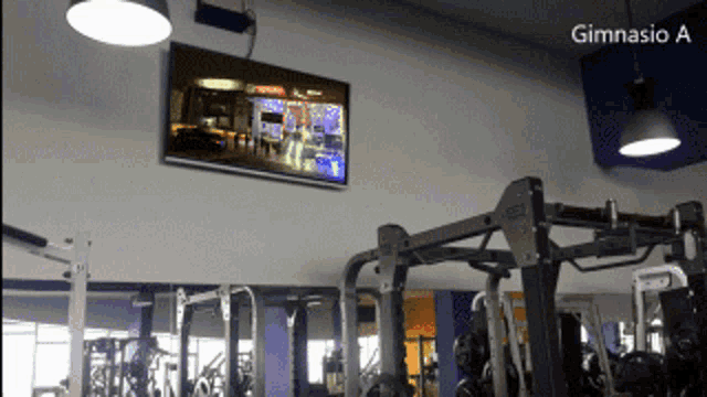 a gym with a tv hanging from the ceiling and the words gimnasio a on the bottom
