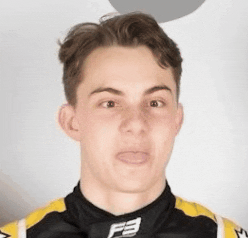 a young man is making a funny face while wearing a black and yellow shirt with the letter f on it .