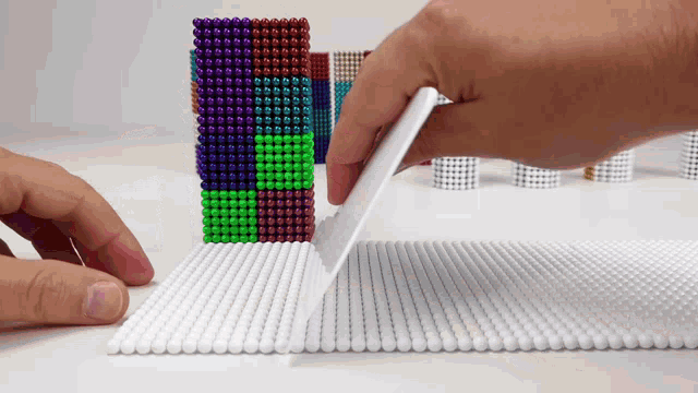 a person is playing with a bunch of magnetic balls