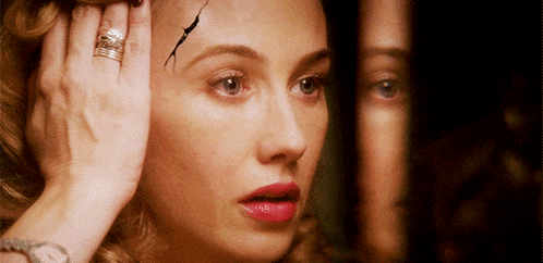 a woman with a ring on her finger is looking at her reflection in the mirror