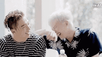 two men are hugging each other and laughing .