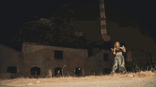 a woman in a black bra and green shorts is dancing