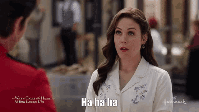 a woman in a white shirt says " ha ha ha " in front of a man in a red uniform