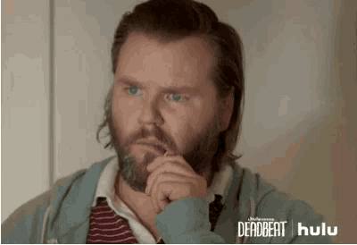 a man with a beard is wearing a blue hoodie and a striped shirt and tie .
