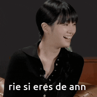a woman is laughing while sitting on a couch and the words rie si eres de ann are on the bottom