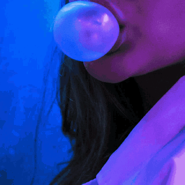 a woman blowing a bubble of gum in her mouth