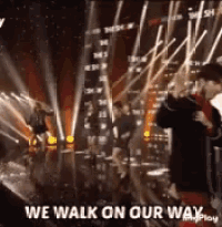 a group of people dancing on a stage with the words " we walk on our way " on the bottom