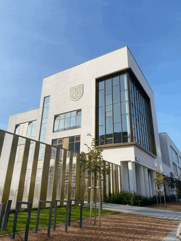 a large white building with a shield on the front of it