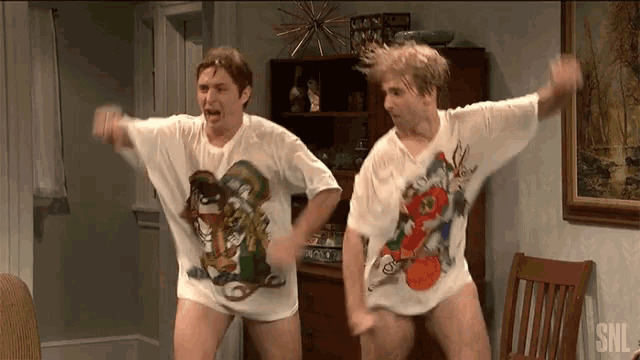 two men are dancing in a living room while wearing shirts that say snl on them