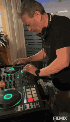 a man wearing headphones and a black shirt with the word excel on it is playing music