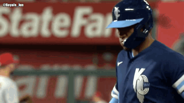 a baseball player is standing in front of a state farm sign