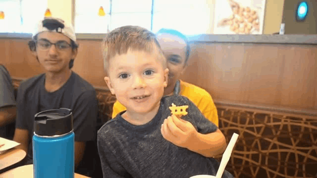 a little boy is eating french fries in a restaurant