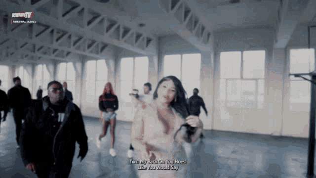 a group of people are dancing in a room with the words turn my back on you hoes like you would say