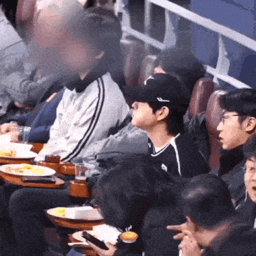 a group of people are sitting at tables with plates of food