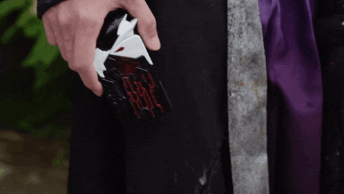 a person is holding a black and white object that looks like a sword .