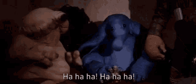 a group of animals are sitting next to each other in a dark room and laughing .