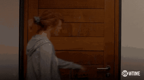 a man and a woman are standing in front of a door .