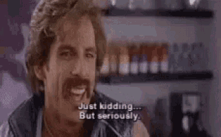 a man with a mustache is talking and saying `` just kidding ... but seriously '' .